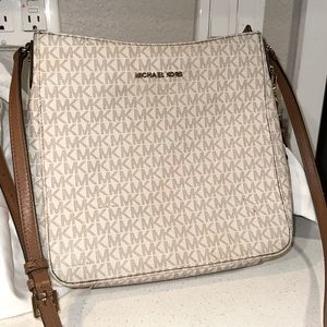 This is a Michael Kors crossbody bag. Beige color with brown adjustable strap